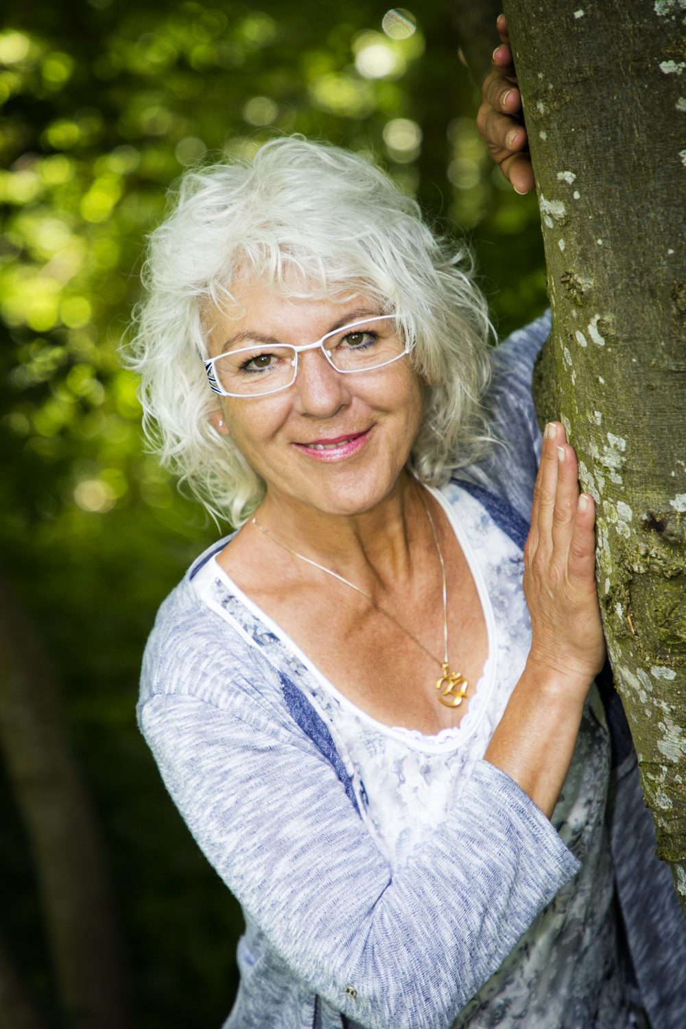 Diana Thommen im Wald, an einen Baum gelehnt