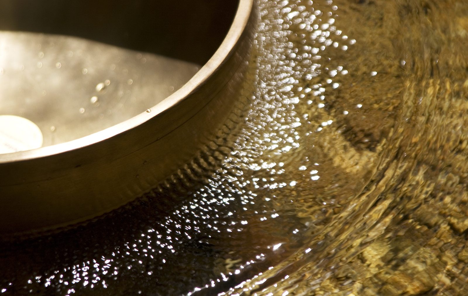 Eine tibetische Klangschale aus der Nähe, das Metall glänzt warm im Licht